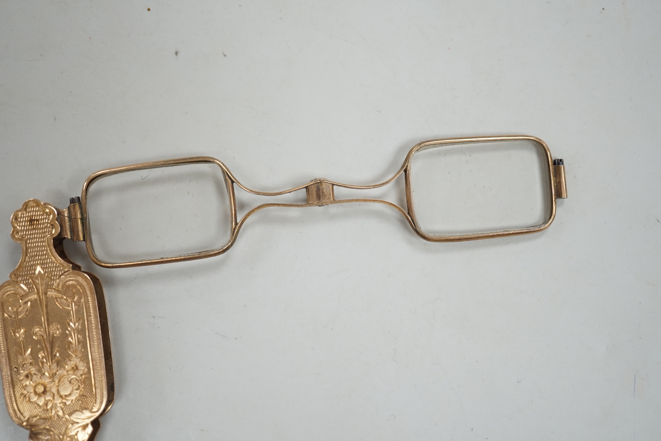 A pair of early 20th century engraved yellow metal overlaid lorgnettes.